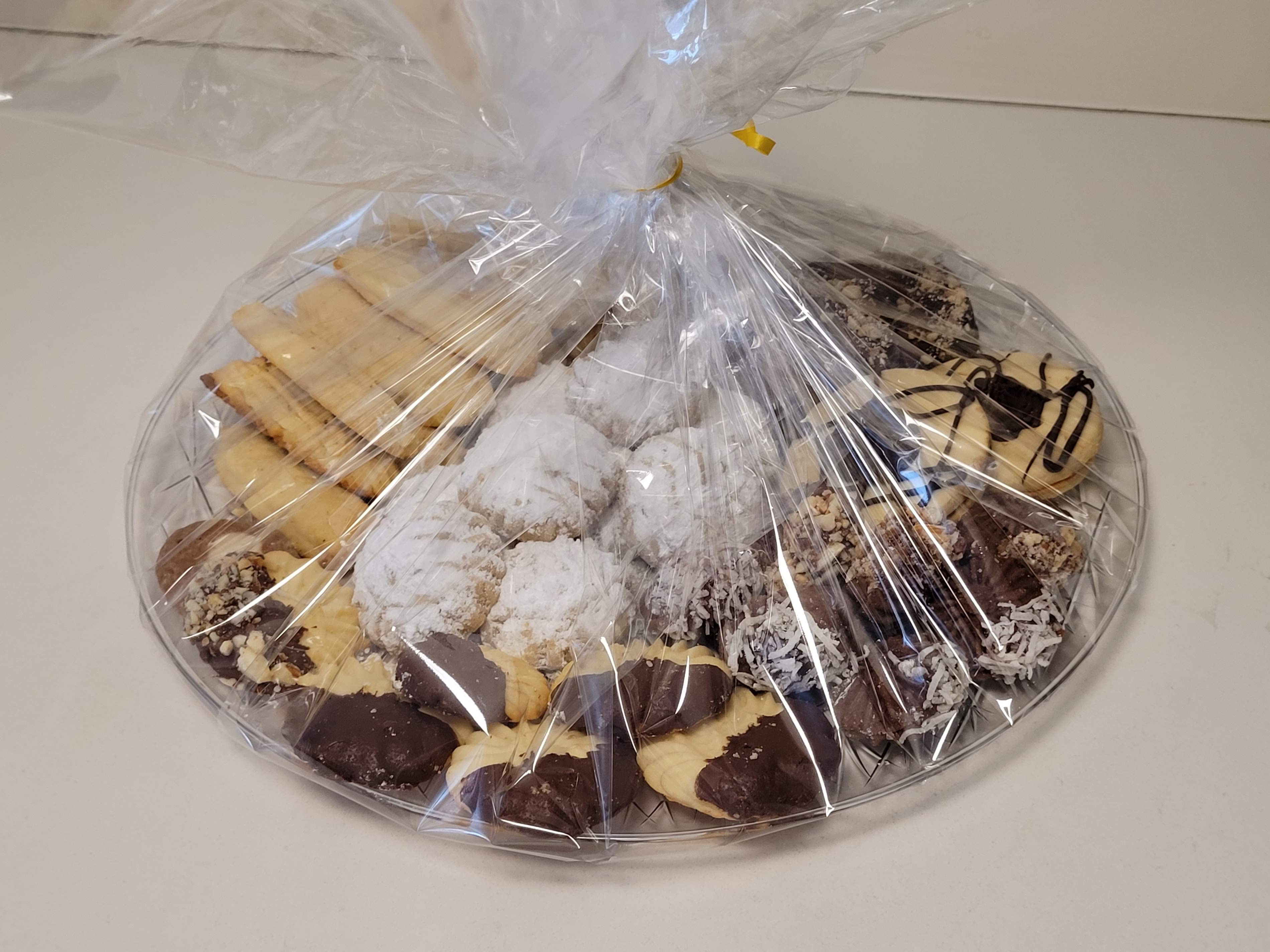 Round platter of assorted Middle Eastern desserts — Kahk with powdered sugar, chocolate-dipped petit four, different shaped Ghorayeba, Laksheir and Nashader biscuits
